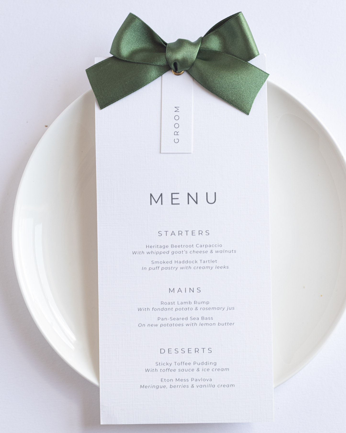 Wedding Menu card with green ribbon on a white plate